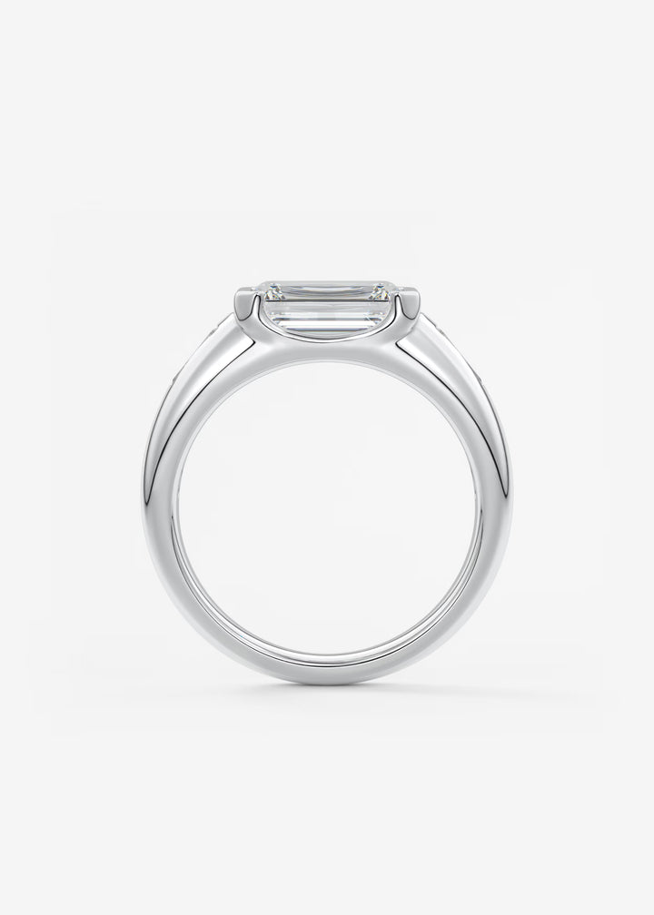 The Lune Trio Emerald Cut Half Bezel Three Stone Engagement Ring with Peekaboo Gallery and Tapered Baguettes#material_white