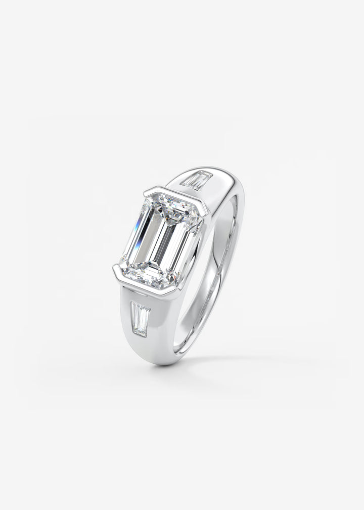 The Lune Trio Emerald Cut Half Bezel Three Stone Engagement Ring with Peekaboo Gallery and Tapered Baguettes#material_white