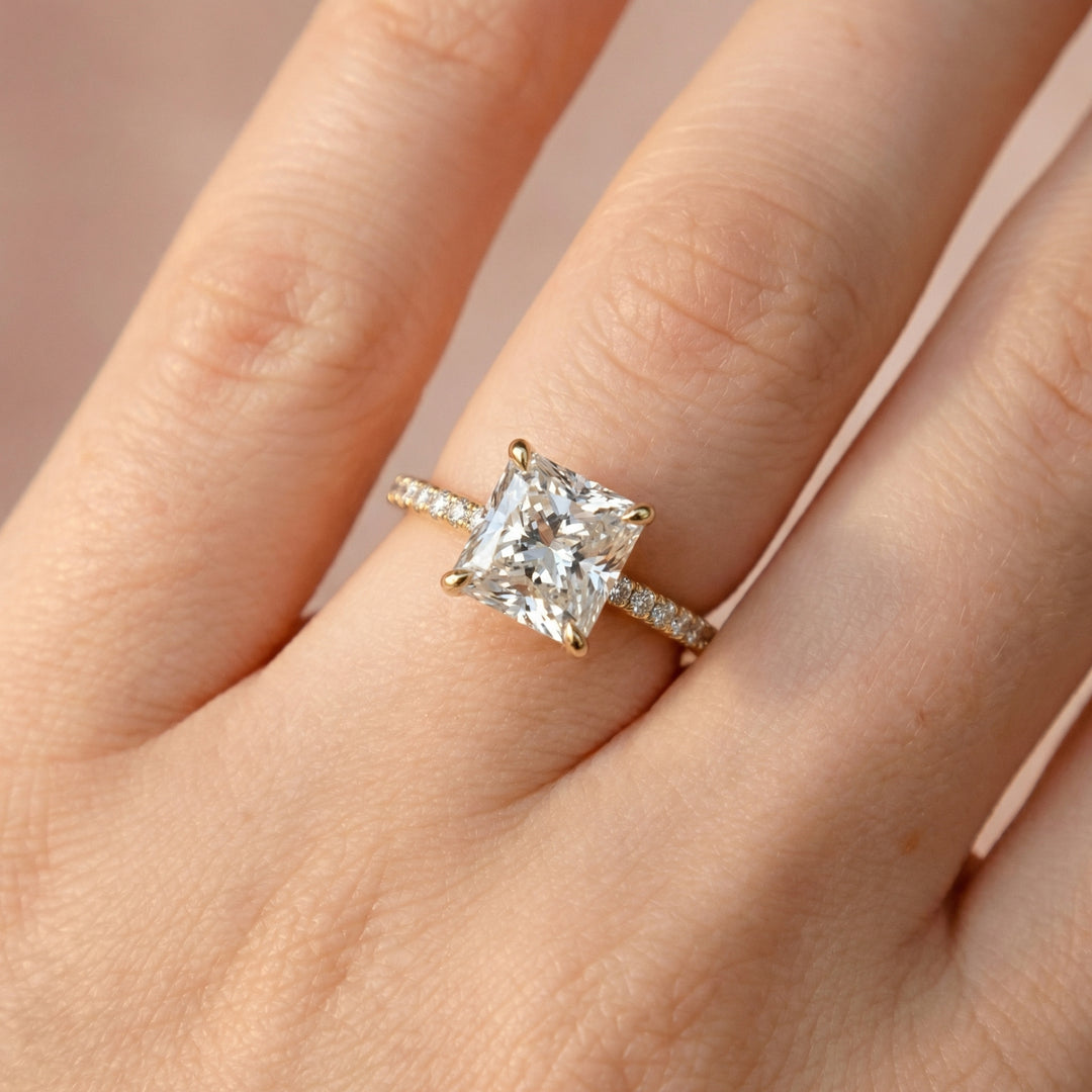 Rose gold ring with a large diamond on a hand against a neutral background #material_gold