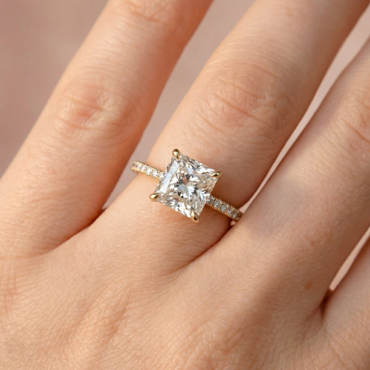 Rose gold ring with a large diamond on a hand against a neutral background #material_gold