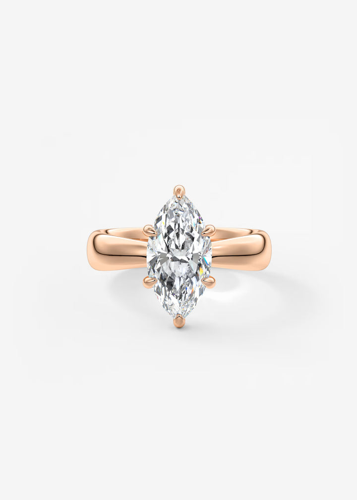 A rose gold ring featuring a marquise-cut clear gemstone in a four-prong setting, centered on a clean white background.#material_rose