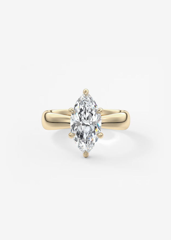A yellow gold ring featuring a large marquise-cut diamond in a four-prong setting, centered on a clean white background.#material_gold