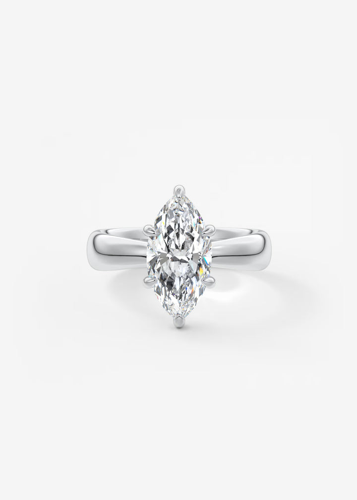 A silver-tone ring featuring a marquise-cut diamond center stone in a prong setting, shown on a clean white background.#material_white