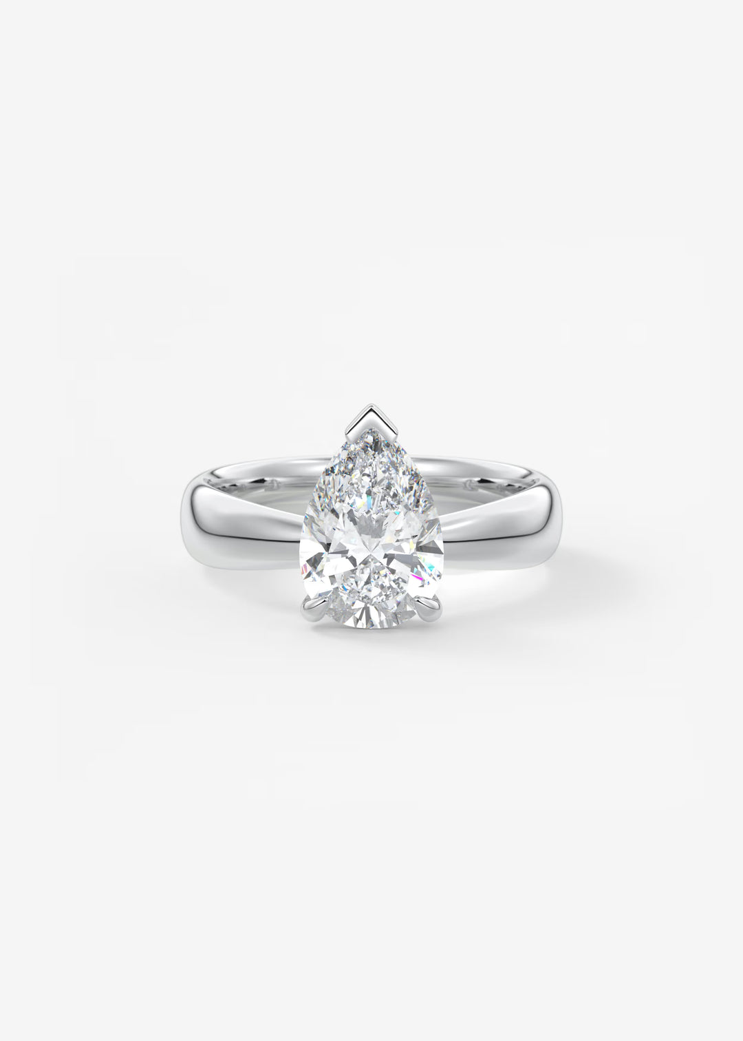 A pear-cut diamond solitaire ring set in a polished silver-colored metal band, centered on a clean white background. #material_white