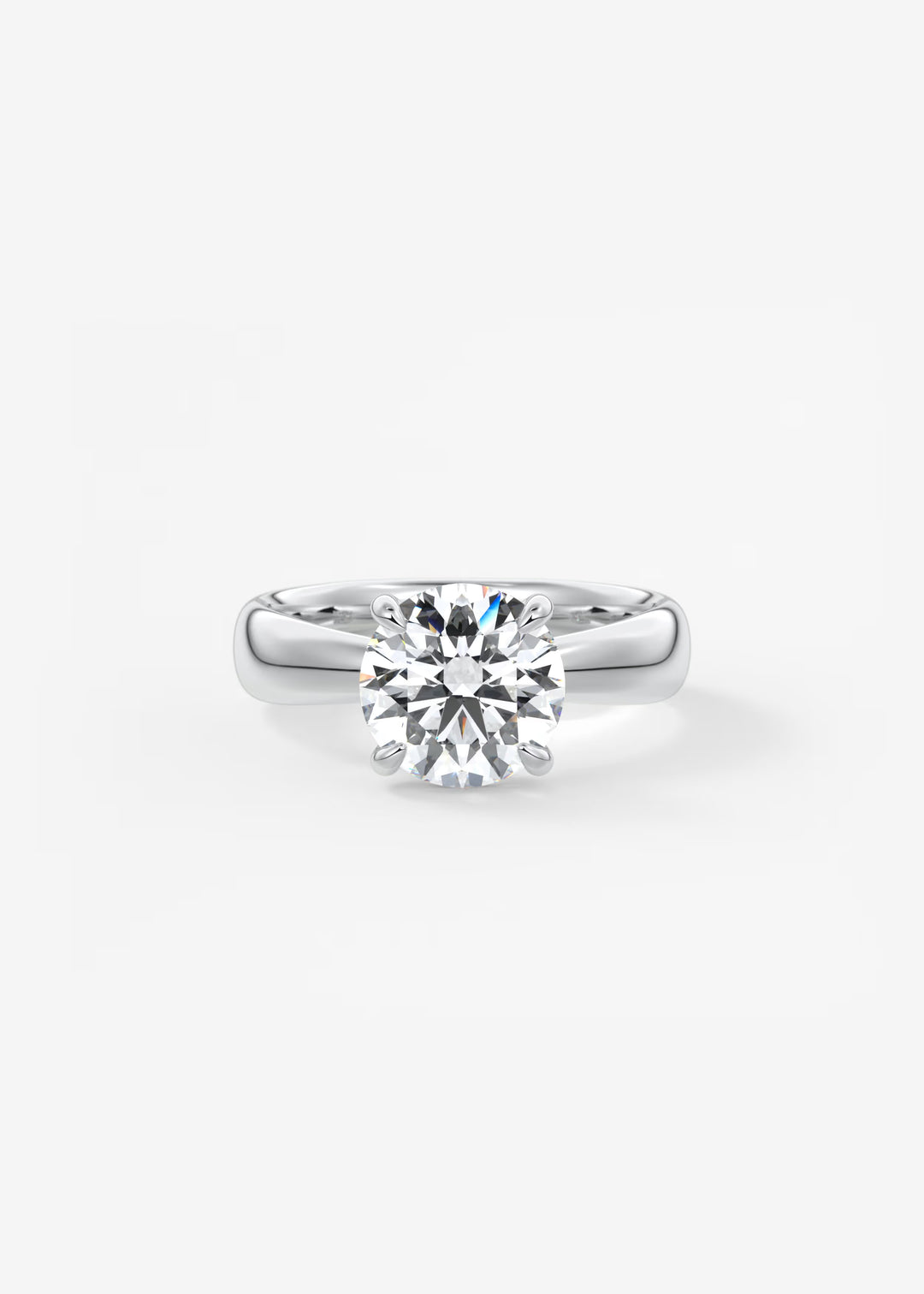 A classic solitaire engagement ring featuring a round brilliant-cut diamond set in a polished silver-colored band, centered on a clean white background.#material_white
