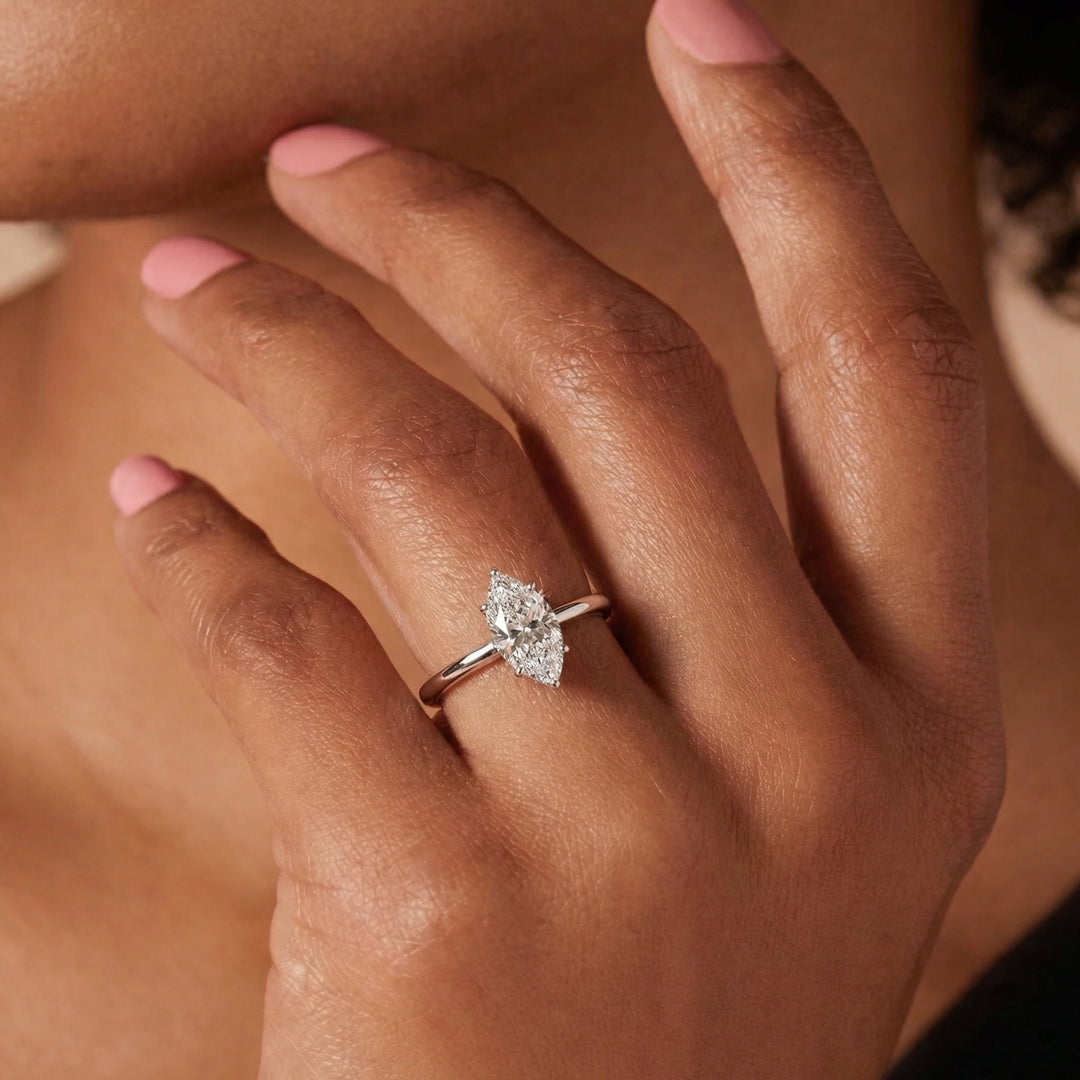 Close-up of a hand wearing a diamond ring on a neutral background #material_white