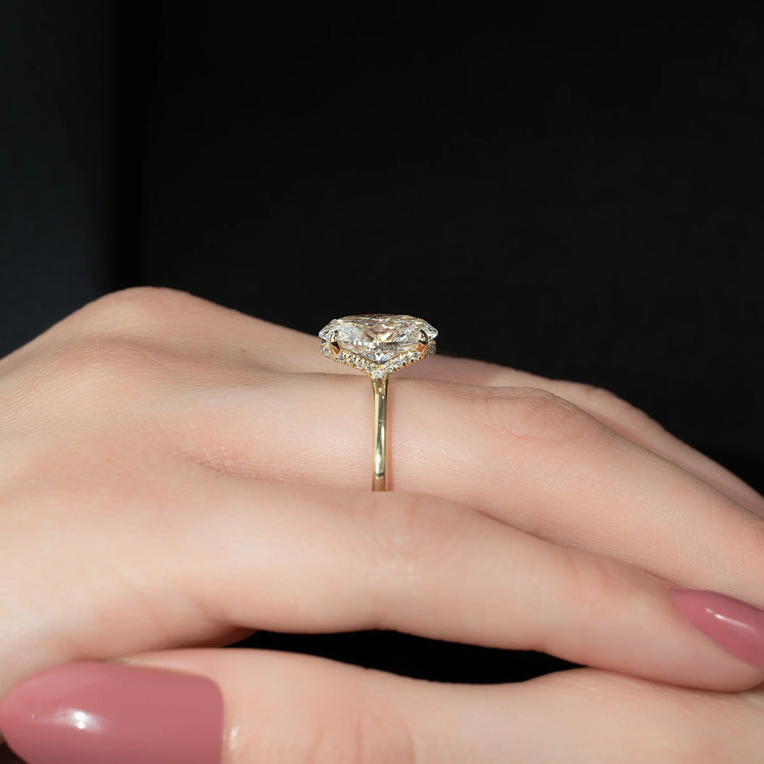 Gold ring with a diamond on a hand against a black background #material_gold