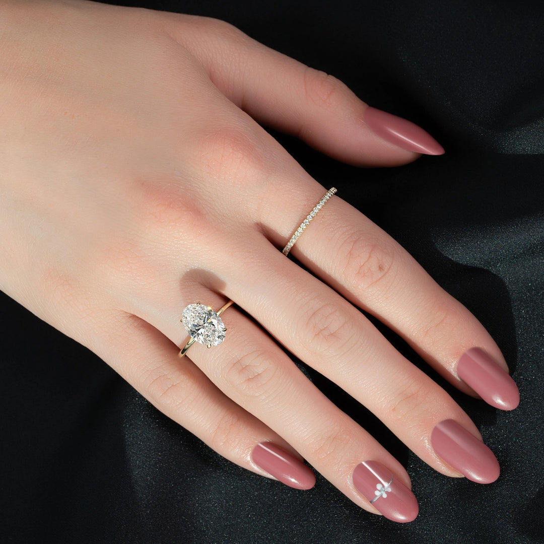 Close-up of a hand wearing two diamond rings on a black background #material_gold