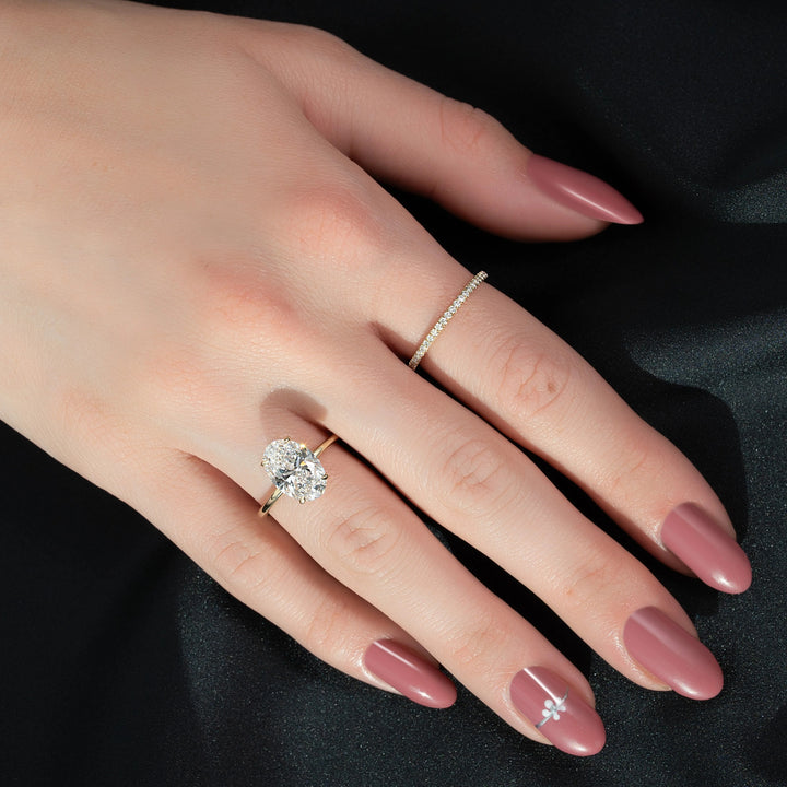 Close-up of a hand wearing two diamond rings on a black background #material_gold