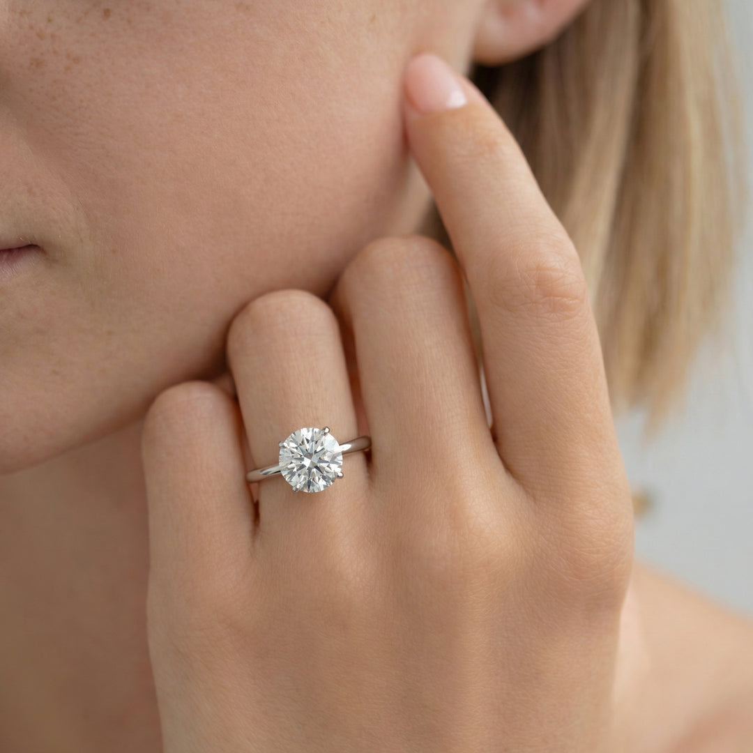 Close-up of a hand wearing a diamond ring with a blurred background #material_white