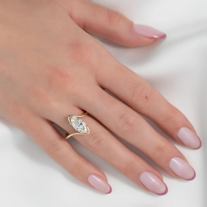 Hand wearing a gold ring with a diamond on a white background #material_gold
