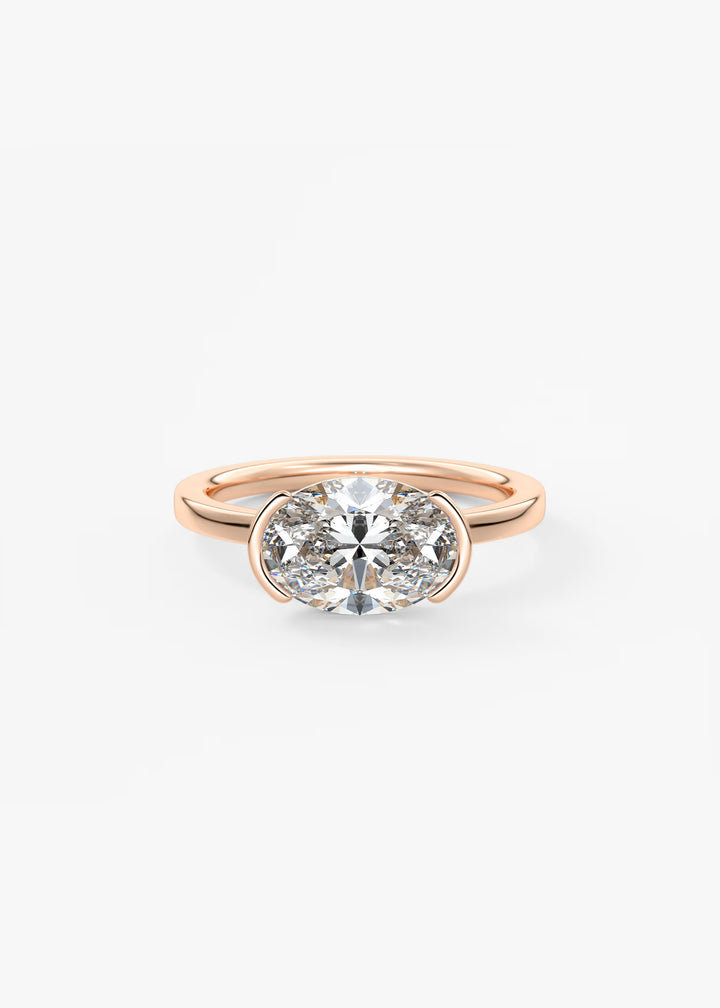 A rose gold ring with a large round-cut clear gemstone in a two-stone setting, shown on a clean white background.#material_rose