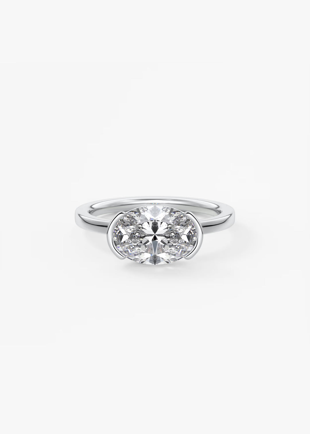 A silver solitaire engagement ring featuring a round brilliant-cut diamond in a bezel setting, shown on a clean white background.#material_white