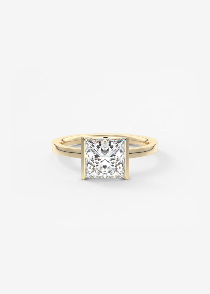 A classic princess-cut diamond engagement ring in a yellow gold band, photographed on a clean, light gray background.#material_gold