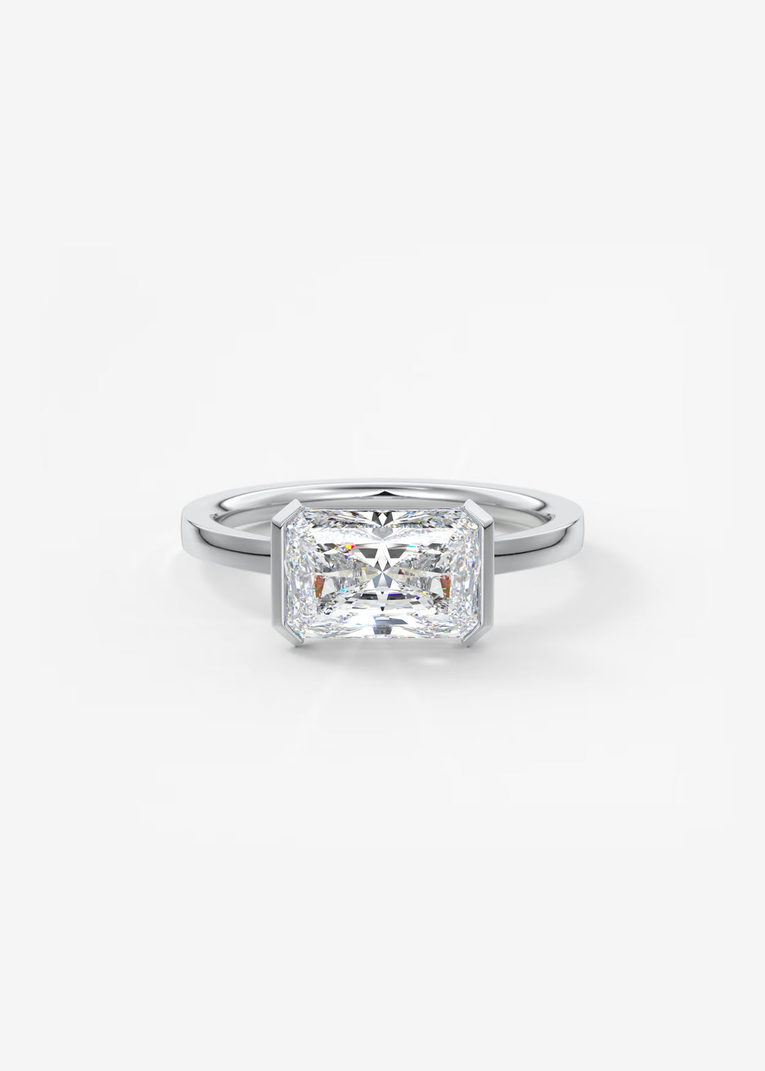 An emerald-cut diamond engagement ring in a polished silver-colored metal band, centered on a clean white background.#material_white