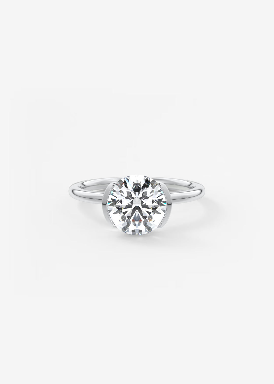 A classic solitaire engagement ring featuring a round brilliant-cut diamond set in a polished silver-colored band, centered on a clean white background.#material_white