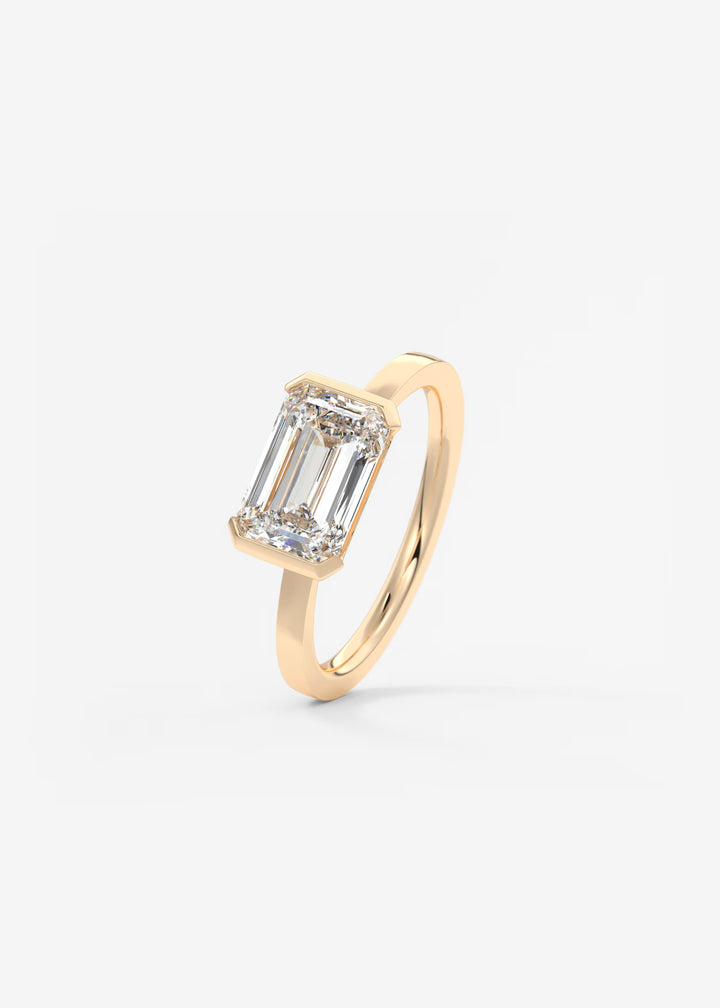 The Vela East West Emerald Cut Engagement Ring with Half Bezel#material_rose