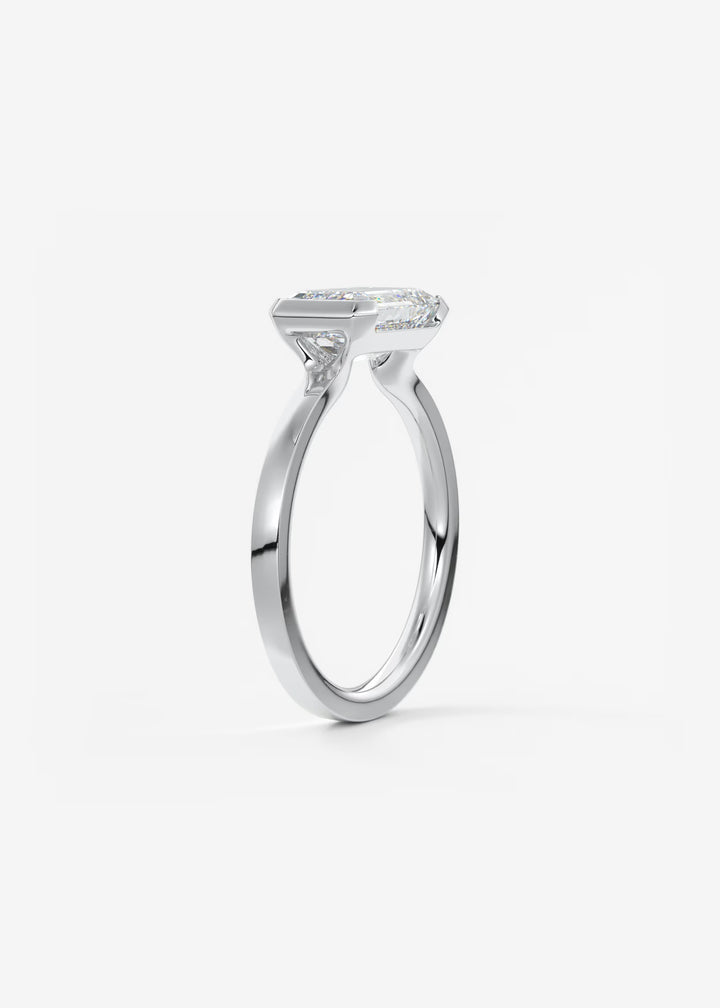 The Vela East West Emerald Cut Engagement Ring with Half Bezel#material_white